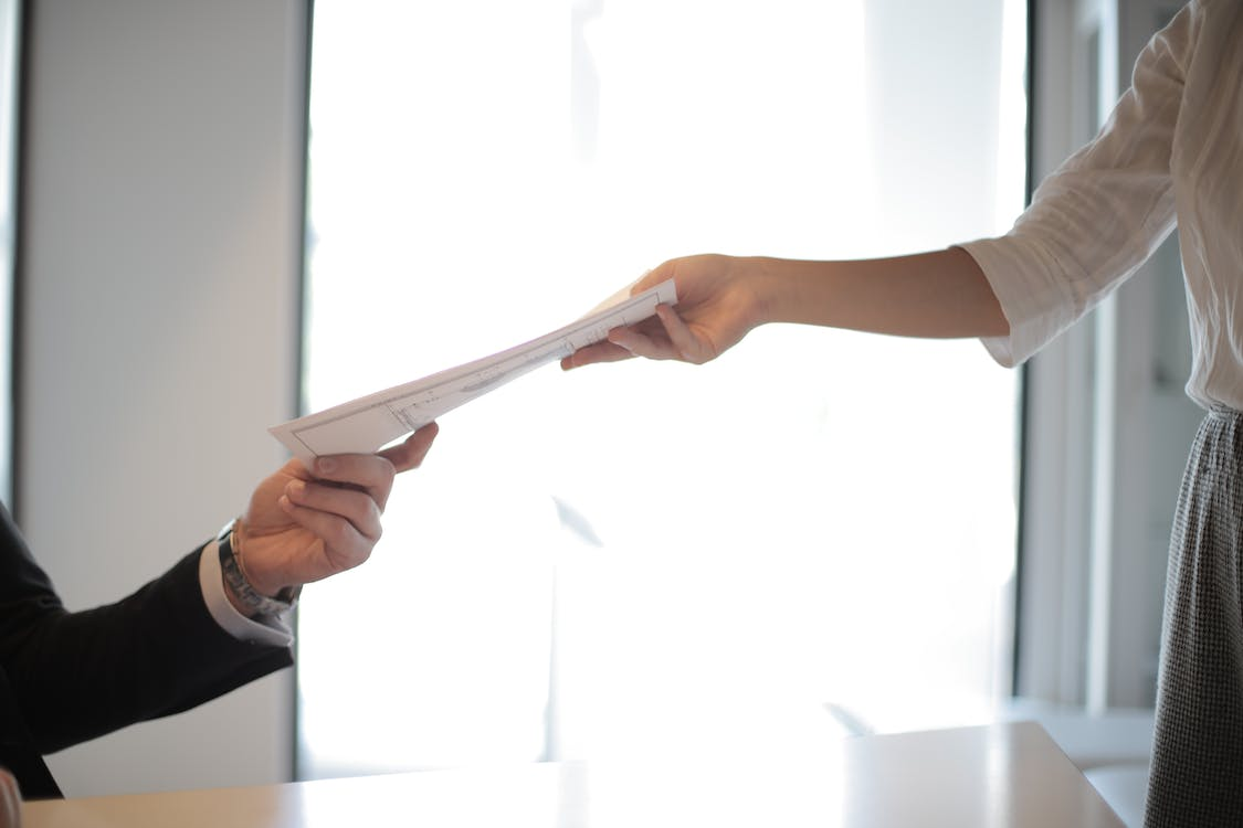 A person handing a document to a public adjuster